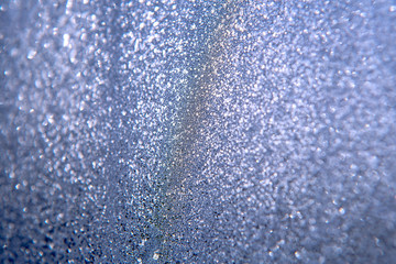 Plakat patterns on glass, frosty drawings in winter on a window, blue background and ice drawings, droplets of fody, reflection through glass,