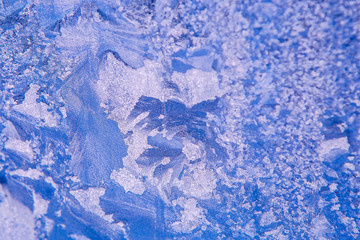 patterns on glass, frosty drawings in winter on a window, blue background and ice drawings,...