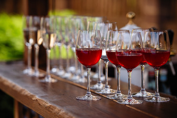 glasses with red wine, fruit drinks are poured into glasses, drinks are poured into glasses, clear glass is on the table