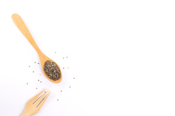 Wooden spoon and wooden fork with plant seeds isolated on white background.