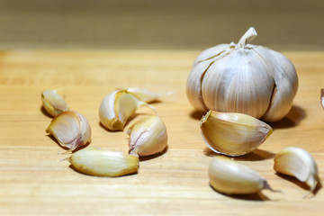Garlic cloves and bulb group on wooden background.