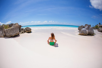 Fototapeta na wymiar Woman enjoying sunny day on the tropical caribbean sandy beach landscape with turquoise sea and blue sky 