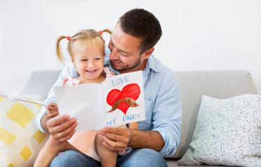 Little daughter congratulating dad with father's day