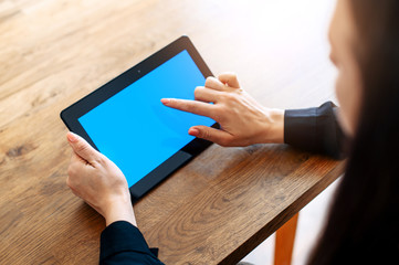 Back view close-up female finger touches of blank tablet screen. Copy space for text. Technology and digitalization concept