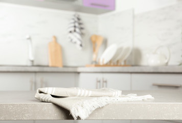 Fototapeta na wymiar Striped cotton towel on light grey table in kitchen