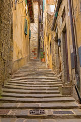 Narrow, cobblestone alley in Cortona, a hill town in the Tuscany region of Italy