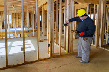 Inspector man inspects house electrical systems electrician holding tablet PC