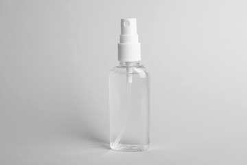 Spray bottle with antiseptic on light grey background