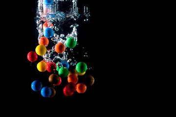 colored balls falling into the water and splashing