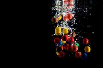colored balls falling into the water and splashing