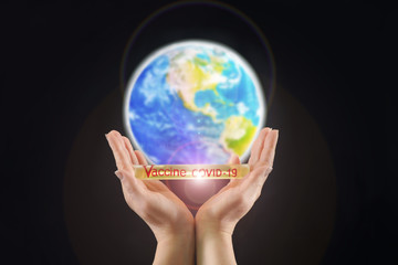 Ampoule with a coronavirus vaccine in female hands against the background of the globe on a black plane. The fight against the disease. Infection Protection Fluid. Vaccine covid-19