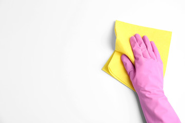 Person in rubber glove with rag on white background, closeup of hand