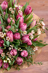 bouquet of flowers with tulips and chamelaucium on wooden background. high quality