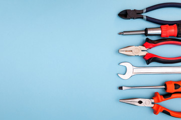 Various tools worker, hammer, wrench, screwdriver, pliers on a blue background, top view with free space