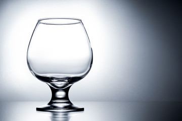 empty clean transparent with glares glass for cognac on gray white background with gradient