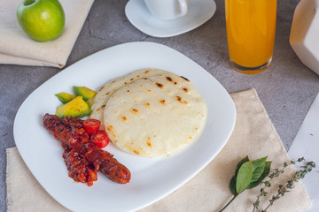 Arepa paisa with sausage and avocado. (Colombian breakfast)