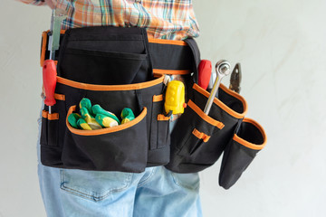 Working tools in a belt bag that a person wears.