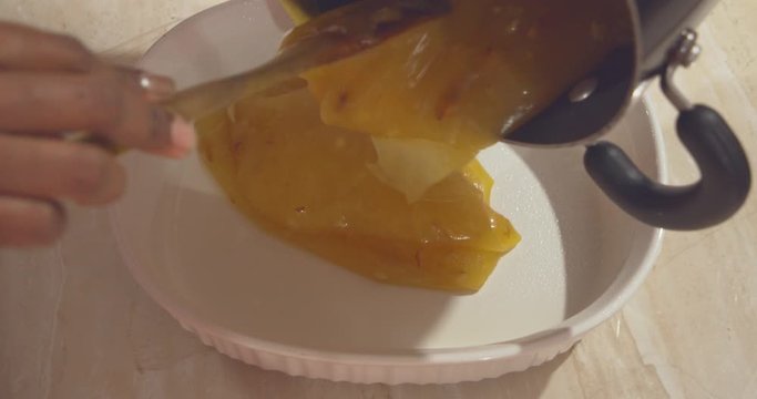 Hot custard powder malwa poured into a pyrex dish to be cooled before it is served