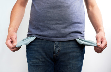 Poor man in jeans with empty pocket. No money concept