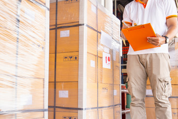 warehouse inventory management, worker hand holding clipboard and large pallet shipment in storage warehouse, business warehouse cargo and logistics