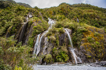 waterfall in the mountains, fox glacier new zealand