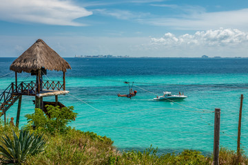 Isla Mujeres (Cancùn), Mexico: seascape with the "zip line" in Garaffon park and the city of Cancun in the background.