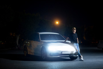Obraz na płótnie Canvas a guy near a modern electric car