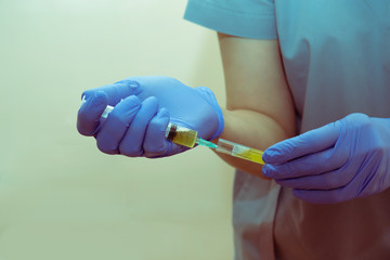 Hands of a nurse collect blood plasma with a syringe from a test tube for prp-therapy.