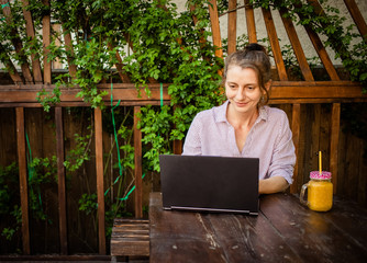woman working on laptop in backyard summer home office