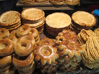 bagels and assorted treat bread products of varying shapes and sizes at busy street food market in China