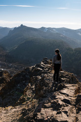 Girl  standing on cliff edge looks into the distance. Landscape,  Travel, lifestyle concept.