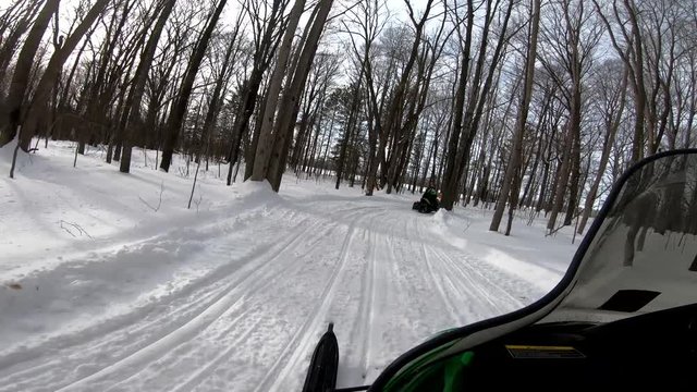 Snowmobiling Onboard View Turns in Woods and out onto a Field