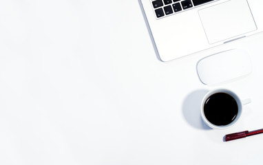 Laptop and coffee cup, top view of desk with white background, copy space