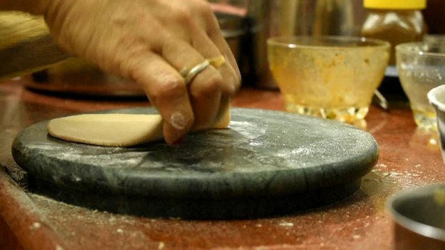 indian woman making round chapati from whole wheat dough