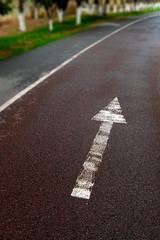 White arrow symbol on the ground