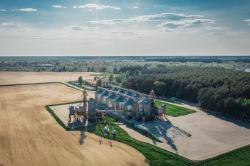 Grain elevator in a field in spring. Agricultural landscape with a granary aerial view
