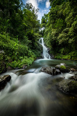 Waterfall landscape. Beautiful hidden Dedari waterfall in tropical rainforest in Sambangan, Bali. Slow shutter speed, motion photography.