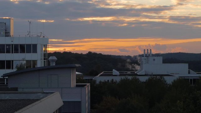 industrial building with smoke at sunset