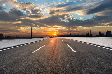 Asphalt road and city skyline with buildings in hangzhou at sunset,China.