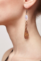 Beautiful woman with galvanic earring in form of maple seed