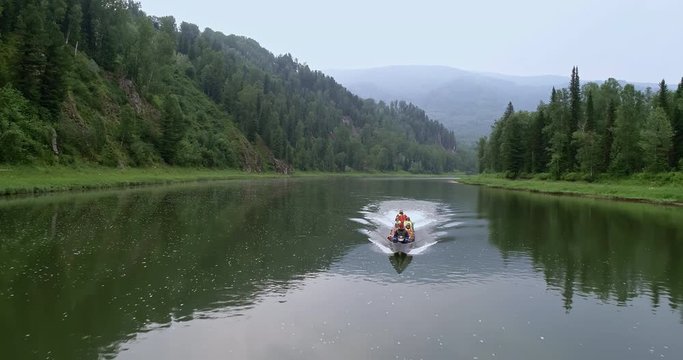 Boat in the river. Aerial view of the boat in the mountain. Summer. Day. People in the boat. a large canoe with a motor in the beautiful mountains. tourists in the wild Siberian taiga. 4k footage