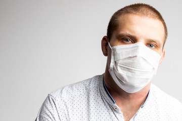 Young man wear masks to prevent air pollution, haze and PM 2.5 dust and smoke pollution on white background. Medical protection against airborne diseases, coronavirus. Man is afraid of getting the flu