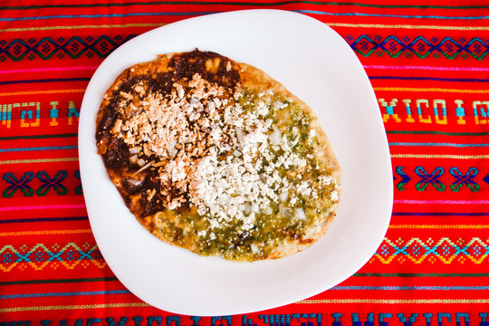 Mexican sopes with grated cheese and green salsa, mexican food spicy in mexico