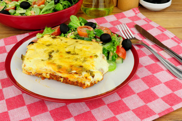 Slow cooked beef and pork ragu lasagne meal with fresh salad and olives
