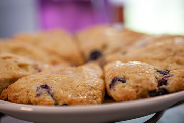 Blueberry scones cut in triangles on a round plate closeup.