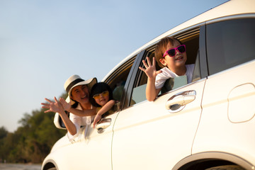 Family of tourists who are having fun and they are reaching hands out the window the family car. Concept happy family on vacation.