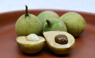 Nutmeg seeds and fruit on a ground plate.