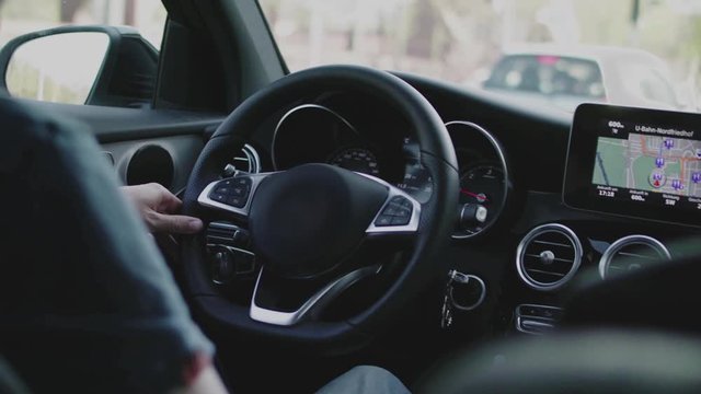Shot of two people driving in a car with black interieur. Mercedes Benz GLC.