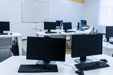 office room with computer tables with keyboard and mouse with a board and a projector