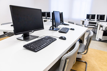 office room with computer tables with keyboard and mouse with a board and a projector